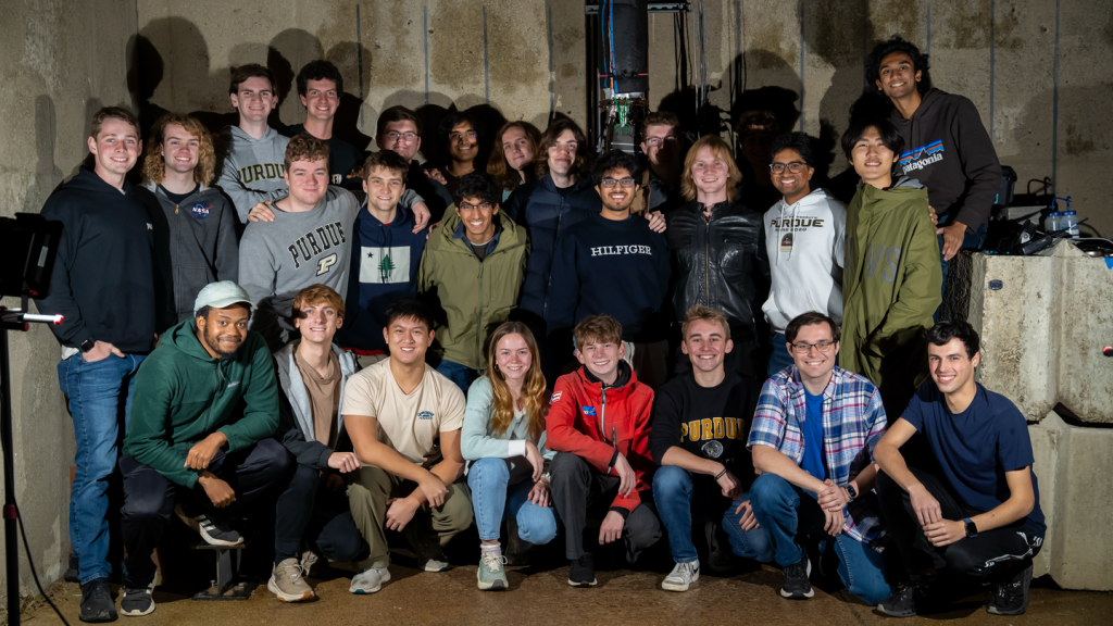 Liquids Homepage A group of students standing in front of a concrete wall