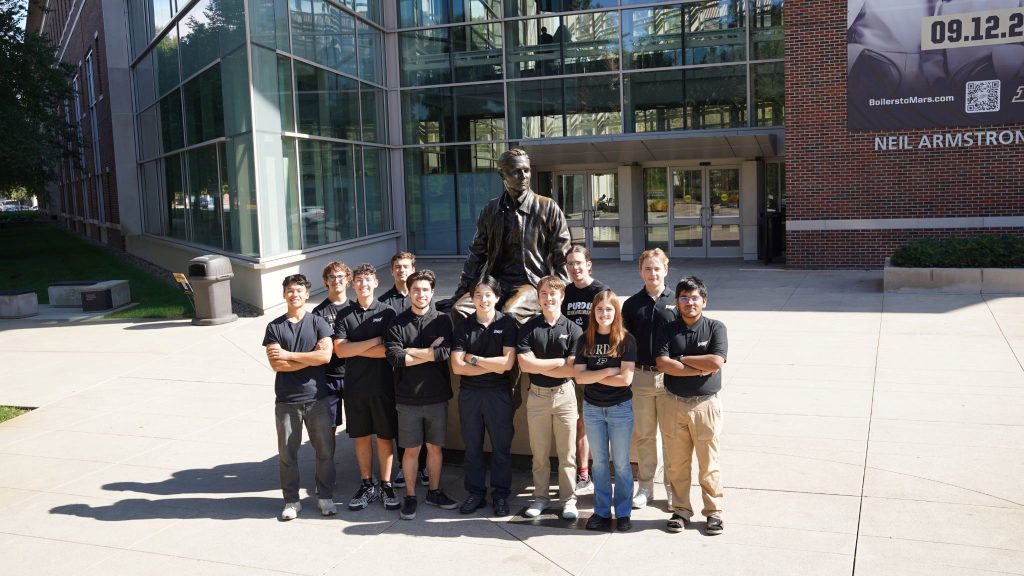 Team Photo PSP Astrodynamics team standing together in front of a statue of Neil Armstrong