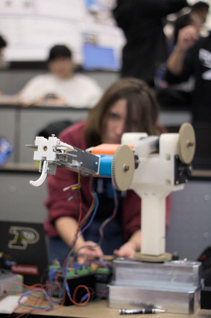 astrobotics arm 2 Robot arm with a student wearing a red jacket watching in the background