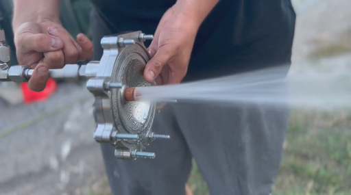AC injector waterflow A student holds a metal part with a spray of water coming out of it