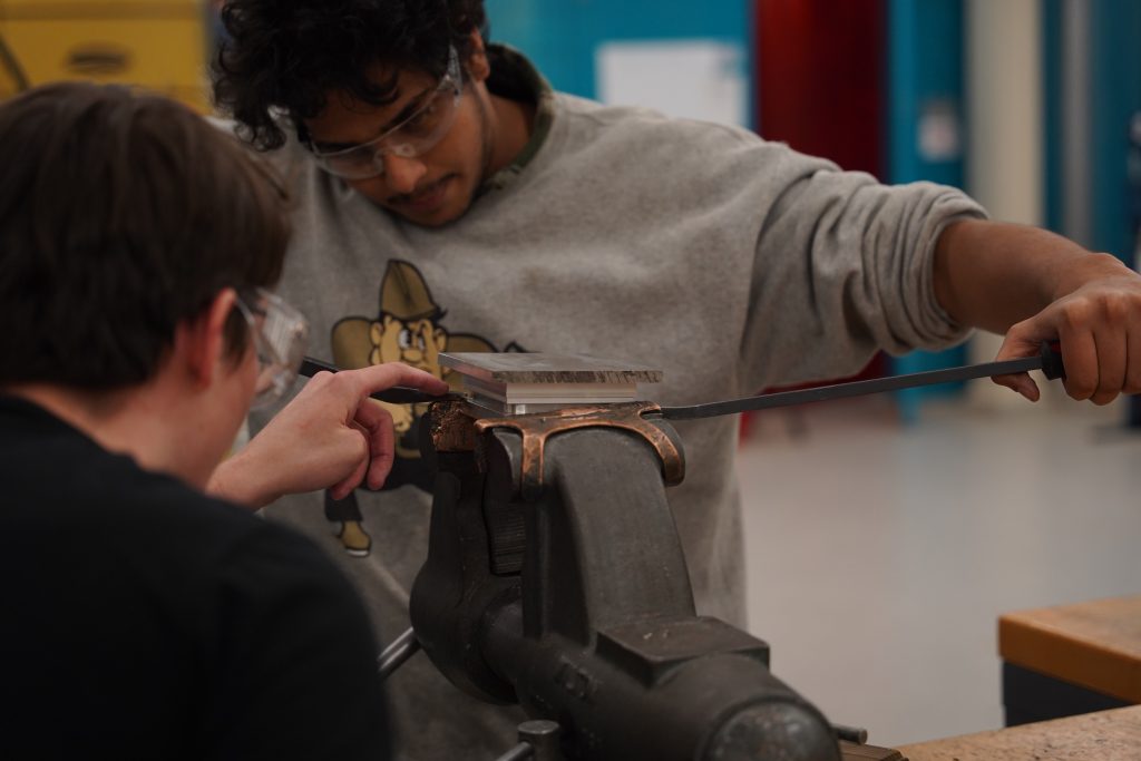 Sats vice work Two students work on a part clamped in a vice