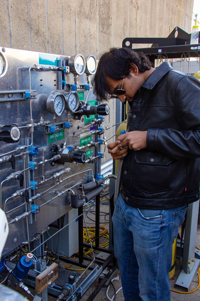 LQ Newsletter 3 A student works on a part in front of a fluid systems panel